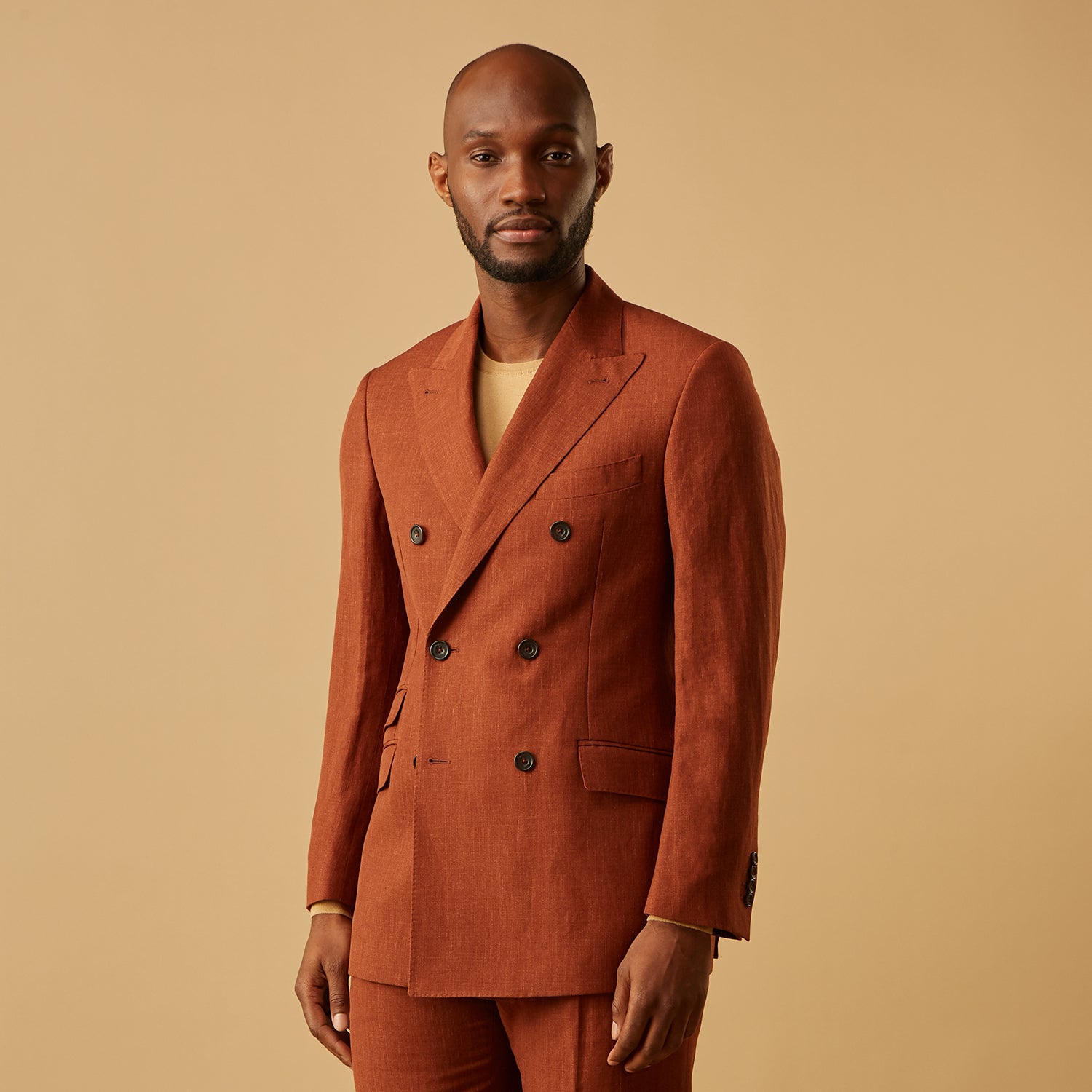 View 2 of product The Turnbull & Asser Rust Linen-Wool-Silk Bertie Blazer is a red double-breasted jacket with peak lapels, black buttons, and flap pockets, tailored in Italy from a luxury linen-wool-silk blend and shown on a white background.