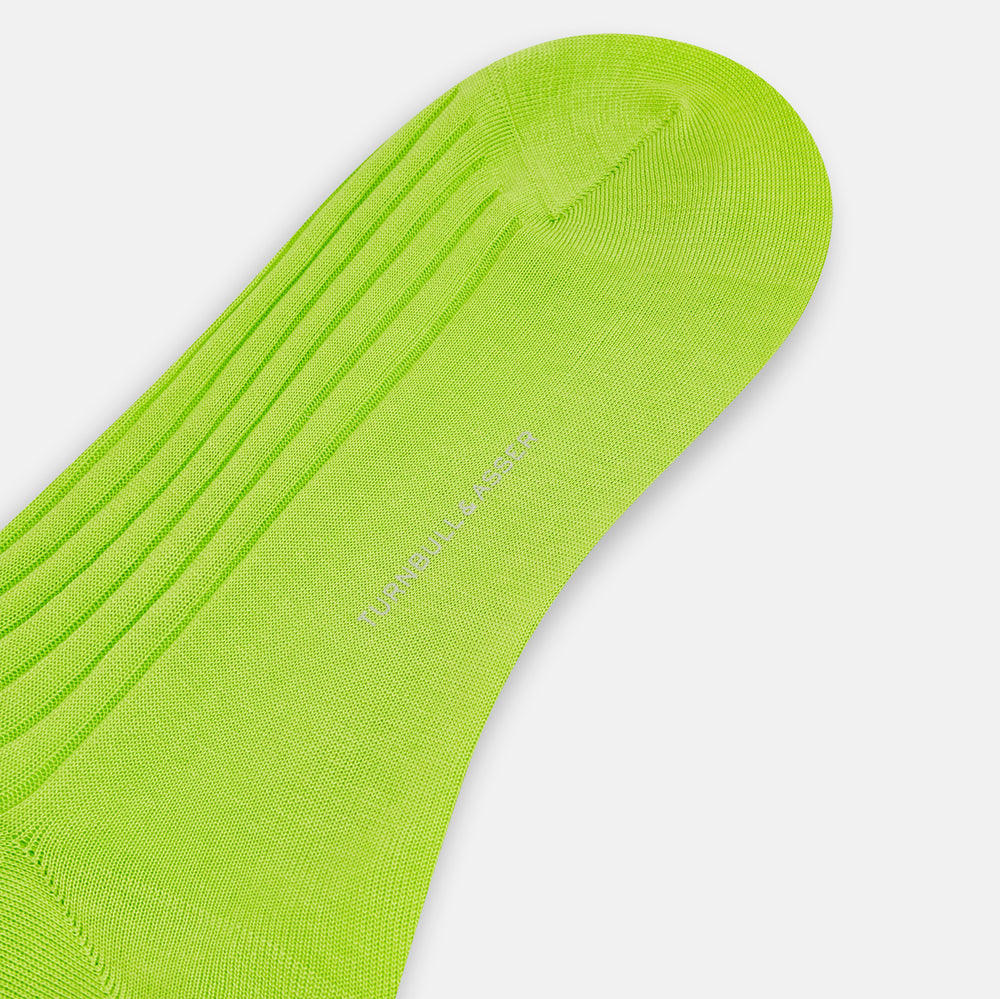 The Turnbull & Asser Lime Mid-Length Sock is crafted from soft mercerised cotton with a ribbed texture and shown against a plain light gray background.