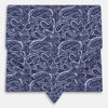 View 1 of product The Turnbull & Asser Lilac Paisley Silk Cravat showcases British elegance with its dark blue paisley pattern on a lilac background, beautifully displayed on a white surface.