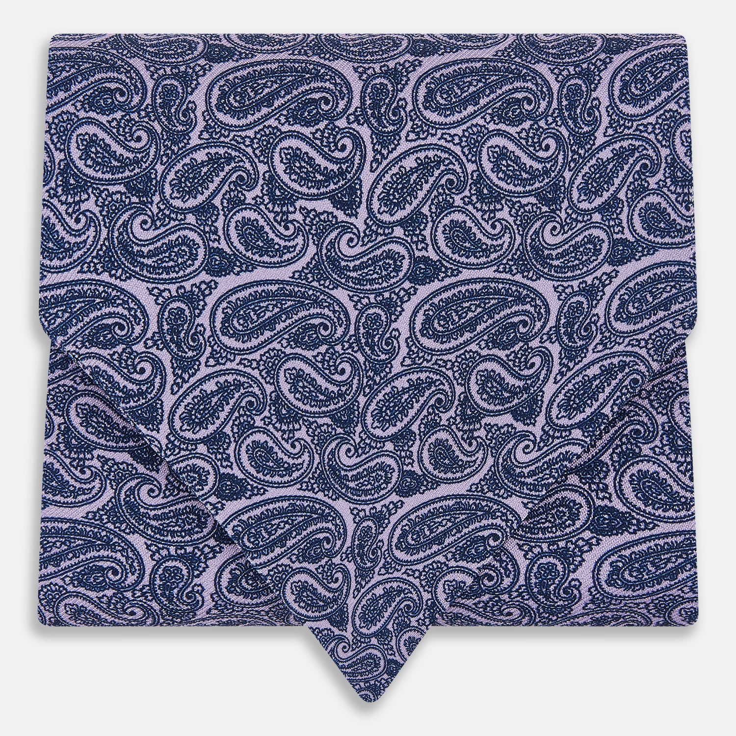 View 1 of product The Turnbull & Asser Lilac Paisley Silk Cravat showcases British elegance with its dark blue paisley pattern on a lilac background, beautifully displayed on a white surface.