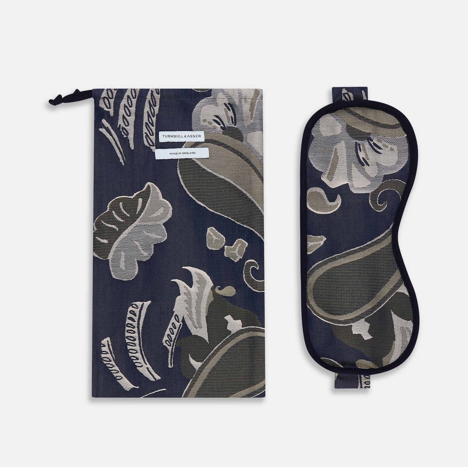 View 2 of product The Turnbull & Asser Navy Bloomsbury Jacquard Cashmere Lined Sleep Mask and Bag features a dark blue backdrop with beige, olive green, and gray floral patterns, plus elastic straps for comfort.