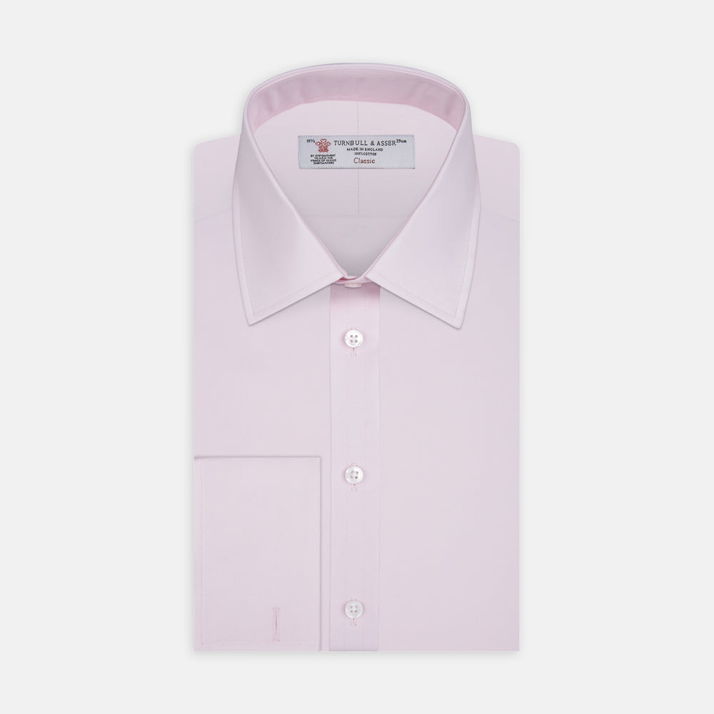 A neatly folded Pink Cotton Shirt with T&A collar and double cuffs by Turnbull & Asser, featuring a classic design with white buttons and an inner label, displayed on a plain white background.