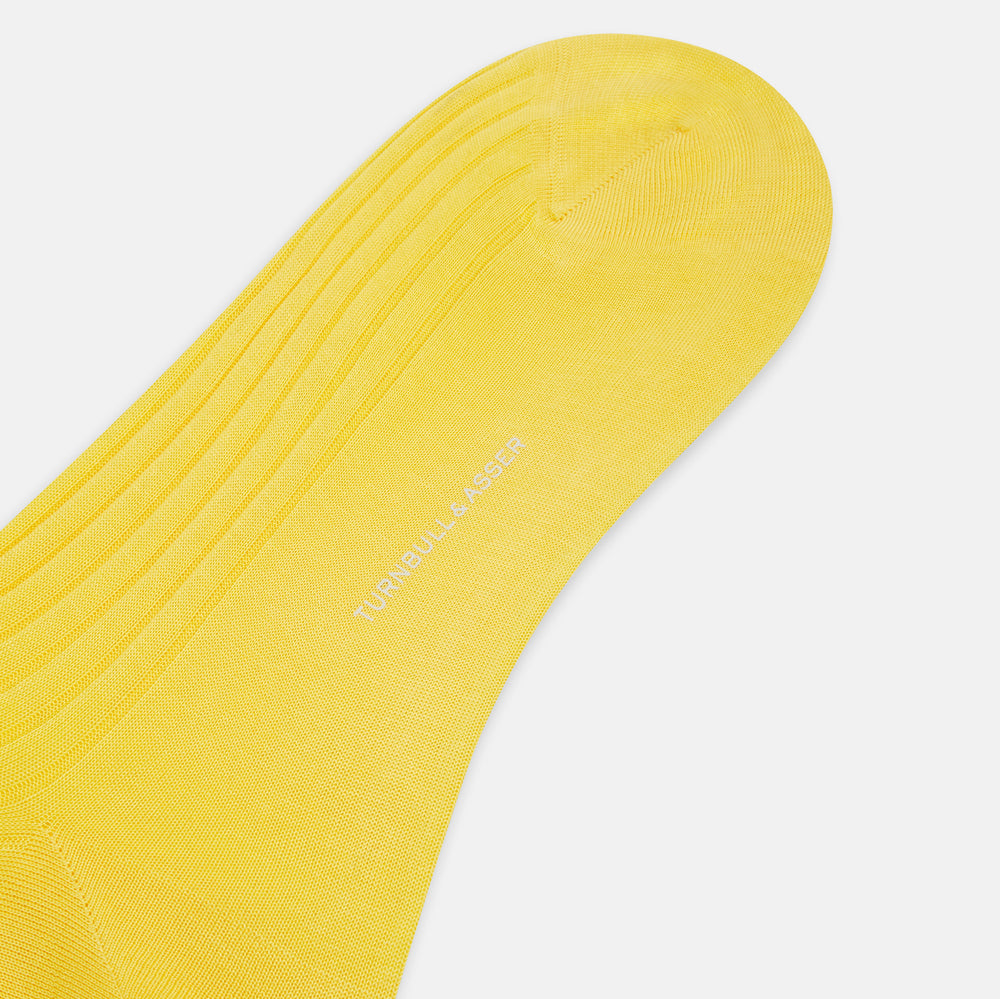 A single Charteuese Lemon Mid-Length Sock by Turnbull & Asser, knee-high and bright yellow with a ribbed Egyptian cotton texture, is displayed upright against a plain white background.