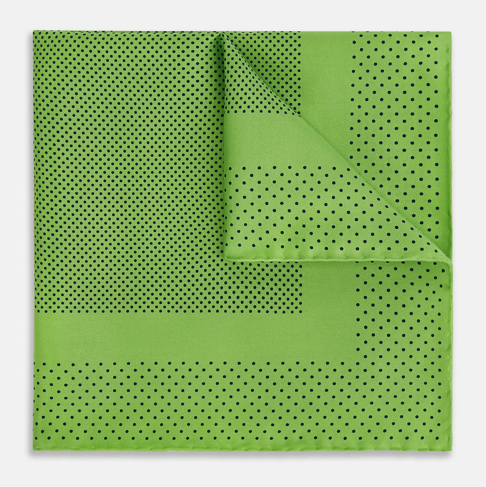 The Turnbull & Asser Kelly Green Dot Silk Pocket Square features small black polka dots and is shown neatly folded to showcase both its front and inner sides.