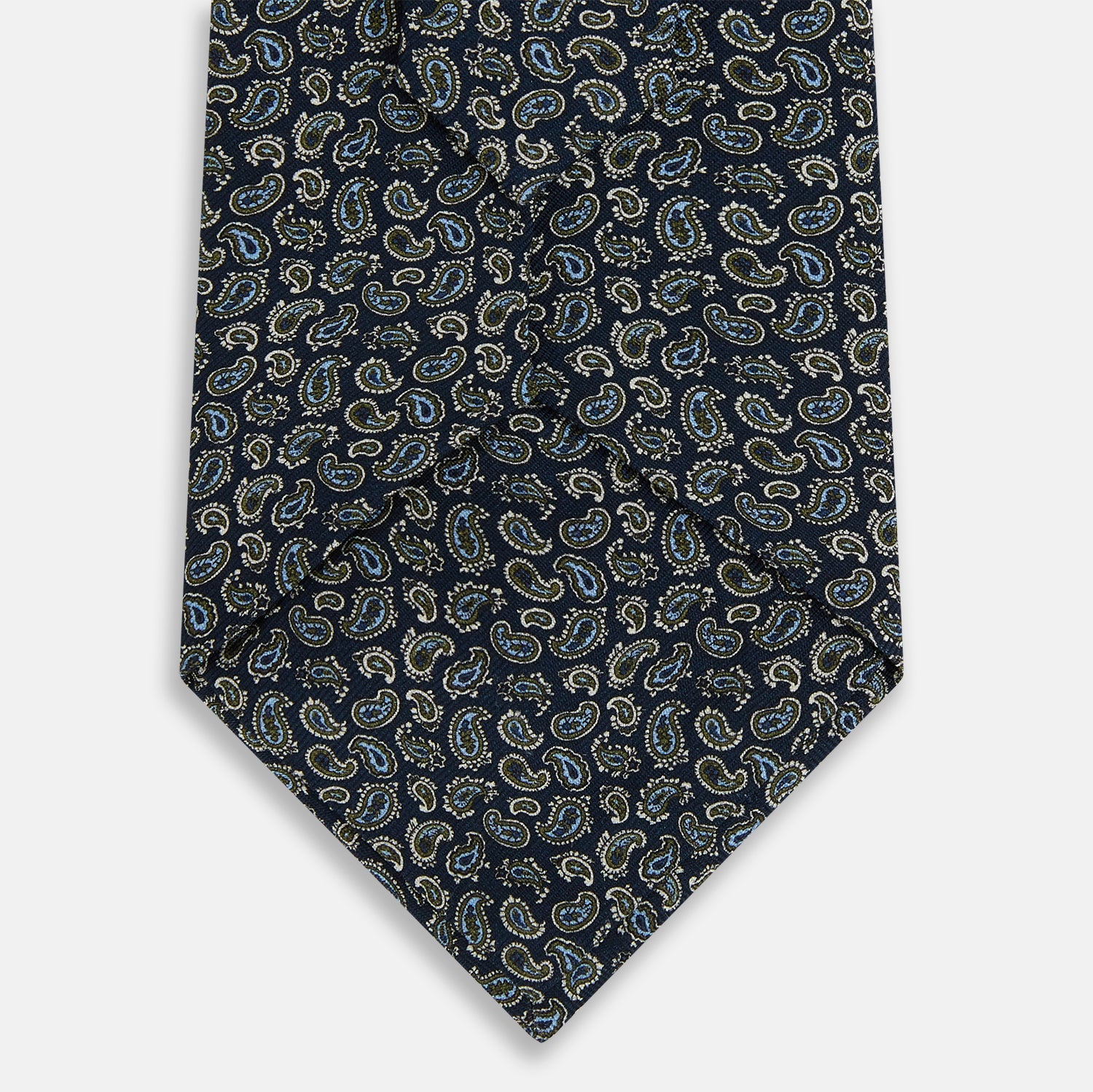 View 3 of product The Turnbull & Asser Navy Paisley Foulard Silk Tie features a refined paisley pattern in blue, white, and beige tones, elegantly rolled and presented against a white background.
