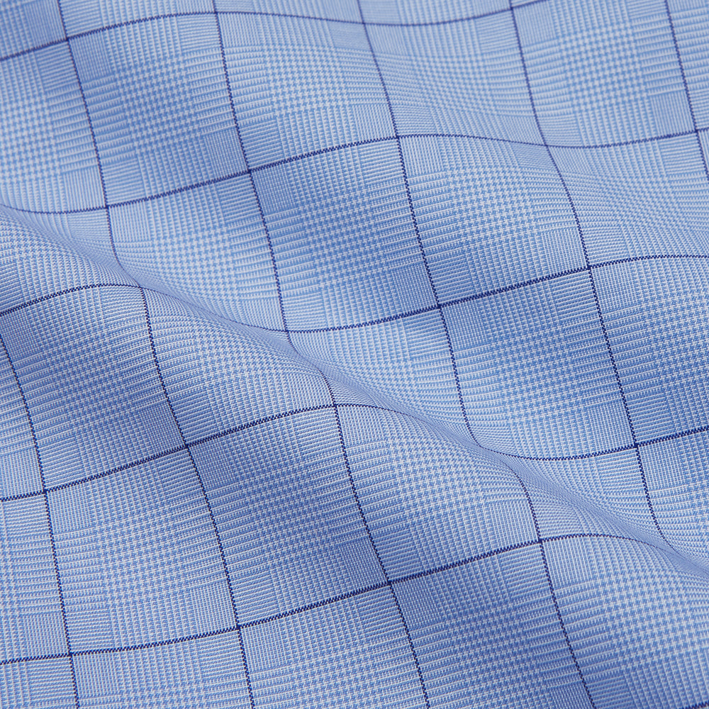 The Blue Prince of Wales Check Mayfair Shirt by Turnbull & Asser is a light blue formal long-sleeve shirt with a subtle check pattern, button-down front, and buttoned cuffs, shown laid flat on a white background.