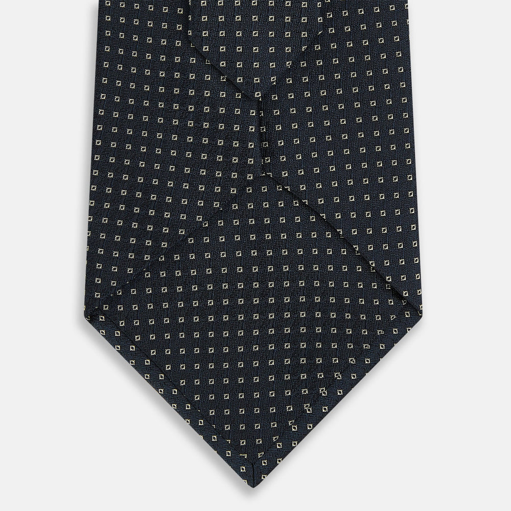 The Navy and White Square Silk Tie by Turnbull & Asser is crafted from English silk with a subtle white square pattern, rolled tip-forward and displayed on a white background for a tailored look.