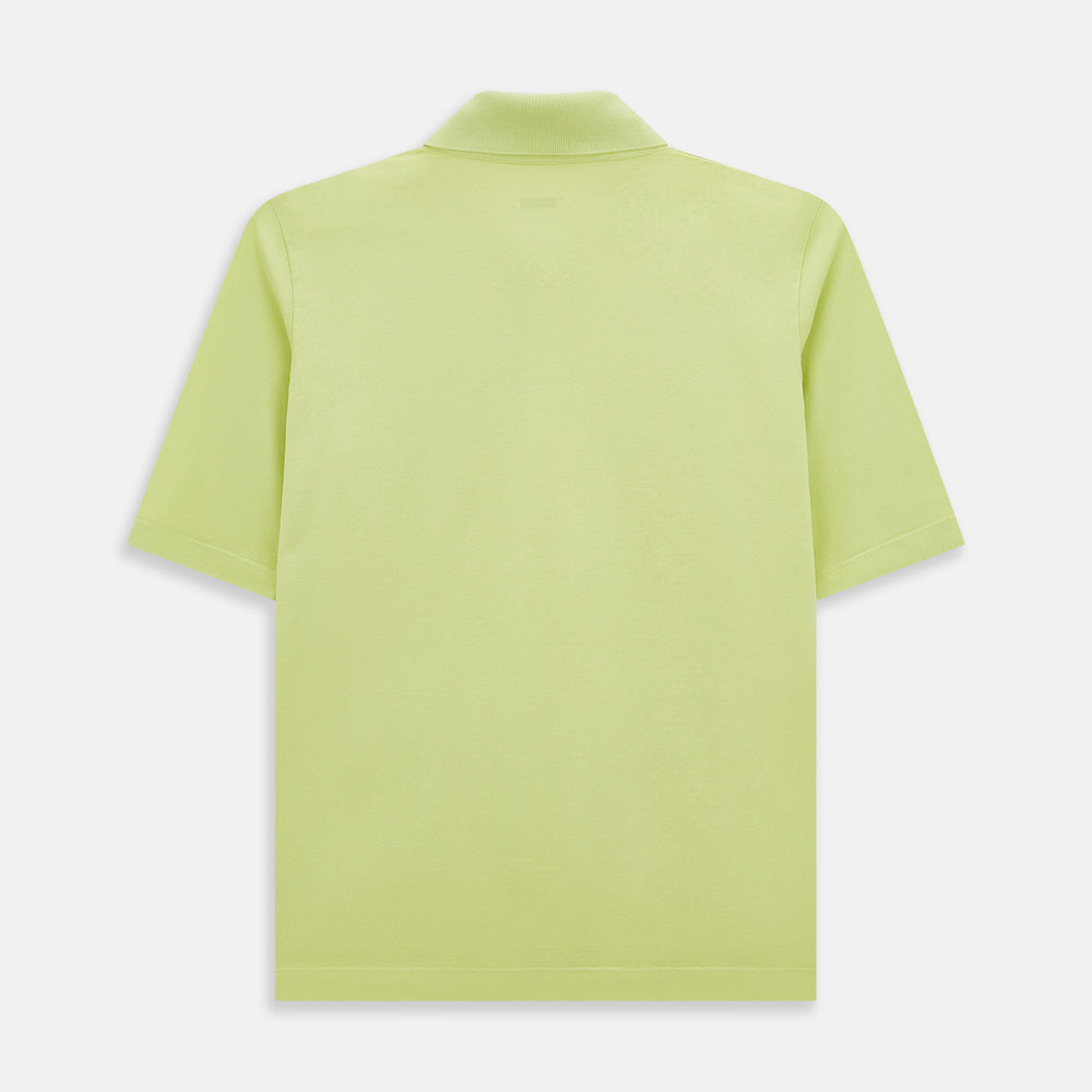 The Turnbull & Asser Lime Green Polo Shirt features a cotton jersey build, short sleeves, a collar, three brown buttons on the placket, and a chest pocket with a button. Shirt shown laid flat on a white background.