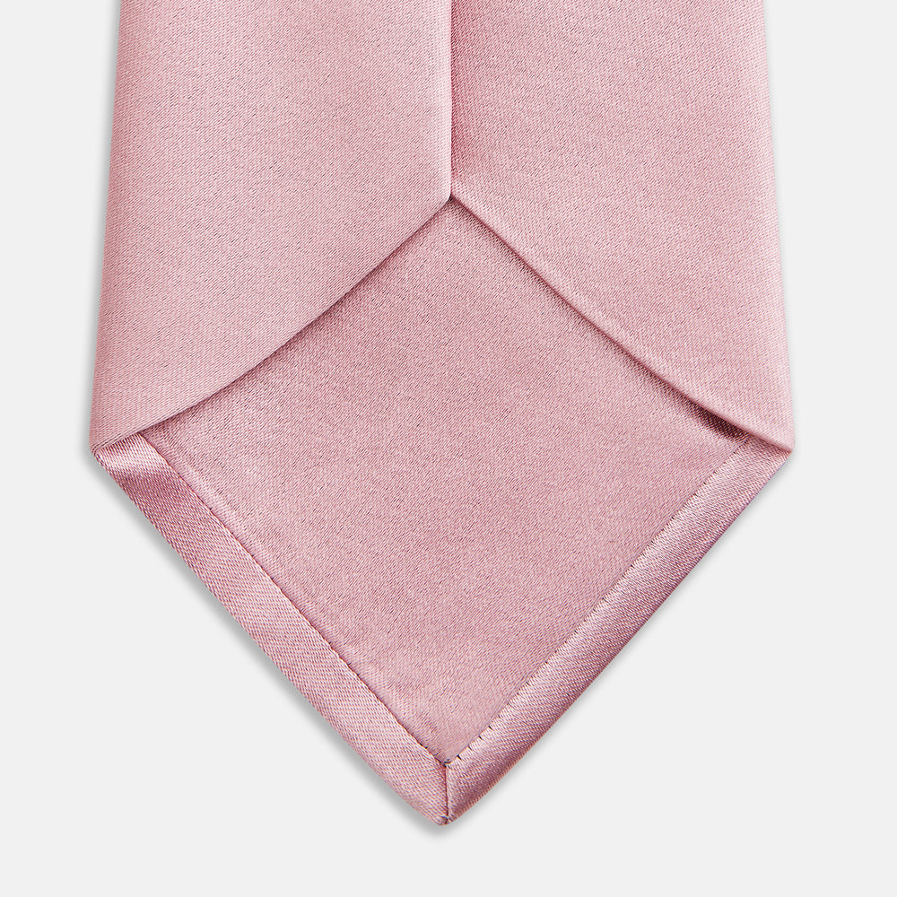 The Turnbull & Asser PINK PLAIN SATIN SILK TIE is neatly rolled and showcased against a plain white background.