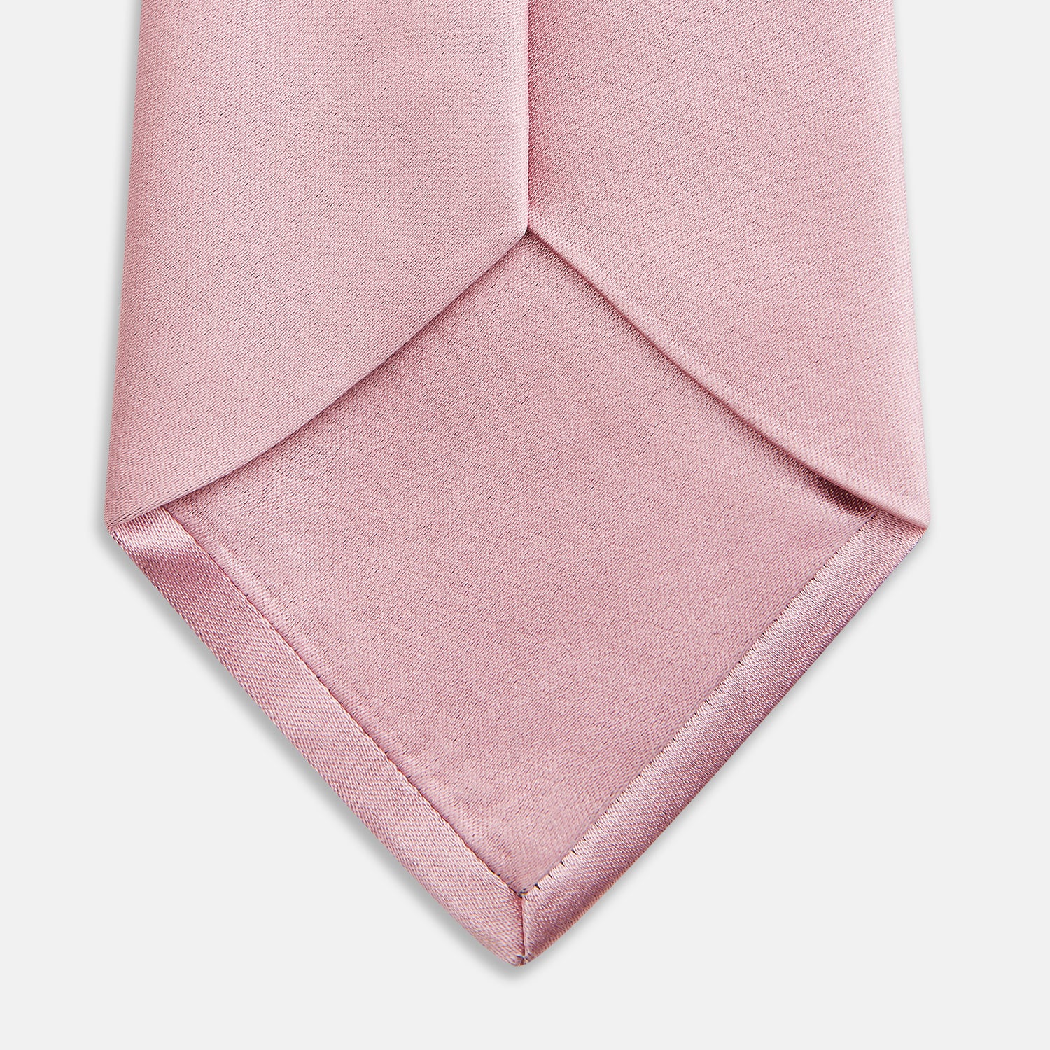 View 4 of product The Turnbull & Asser PINK PLAIN SATIN SILK TIE is neatly rolled and showcased against a plain white background.