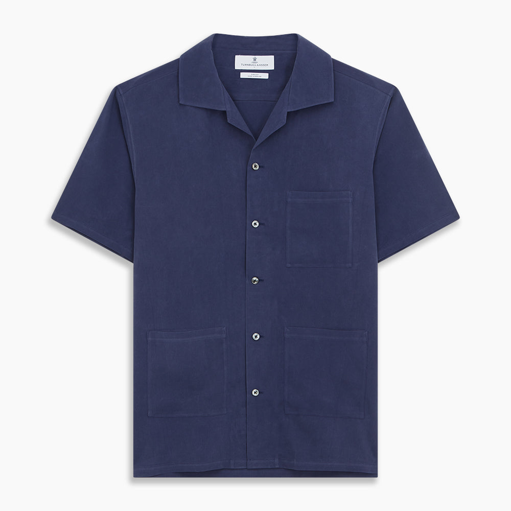 The Navy Silk Holiday Fit Phillips Shirt by Turnbull & Asser features short sleeves, a revere collar, and three front patch pockets, shown laid flat on a white background.