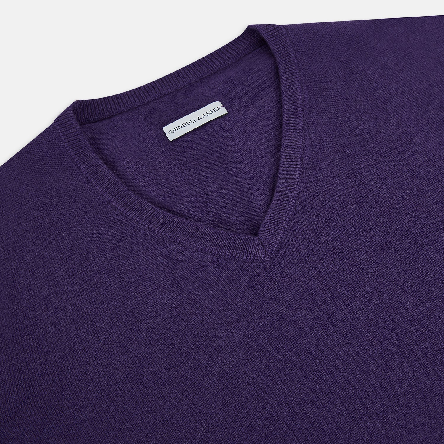 View 2 of product The Turnbull & Asser Purple Cashmere V-neck Jumper features long sleeves with ribbed cuffs and hem—a classic knitwear piece for effortless layering, shown against a white background.