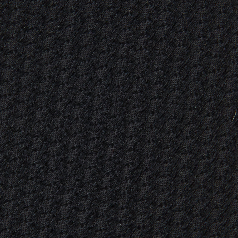 Turnbull & Asser's Seven-Fold Black Lace Silk Tie, featuring a textured finish and pointed tip, is elegantly rolled and displayed on a white background—a timeless accessory for any luxury neckwear collection.