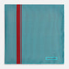 View 3 of product The Turnbull & Asser Turquoise and Red Stripe Silk Pocket Square features thin navy stripes with a bold vertical red stripe, partially folded to reveal the reverse pattern and the brand's logo, showcasing its British heritage.