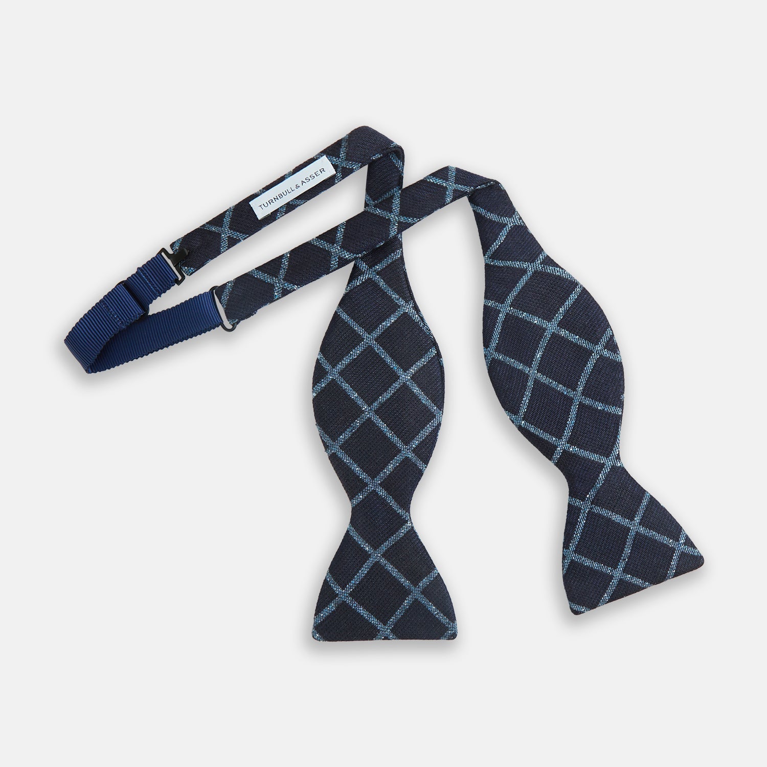 View 2 of product The Turnbull & Asser Blue Diagonal Check Silk Blend Bow Tie, shown on a plain white background, exemplifies British elegance and refined formal etiquette.