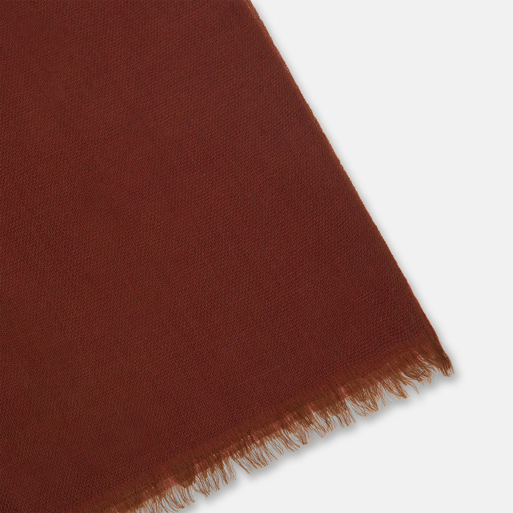 The Plush Burgundy Cashmere Scarf by Turnbull & Asser is neatly folded and draped, featuring subtle frayed edges, and displayed on a plain light background.