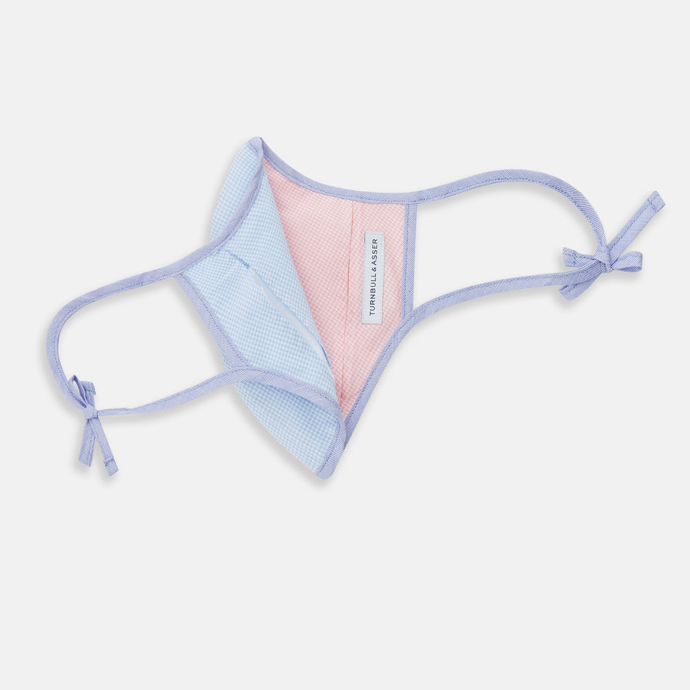 The Turnbull & Asser Pink & Blue Check Commuter Mask features lavender adjustable ear loops tied in bows and comes with 3 Viroformula™ filters. Shown on a plain white background.
