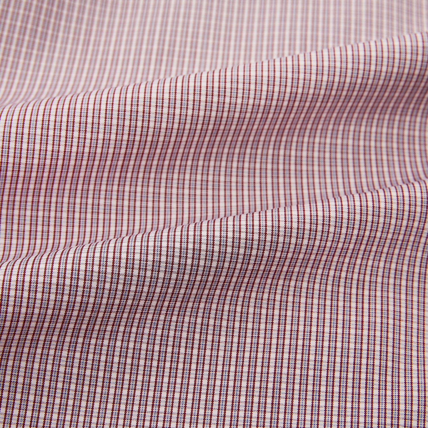 View 6 of product The Turnbull & Asser Burgundy Micro Shadow Check Mayfair Shirt features long sleeves, a classic collar, and white buttons. In light red and white shades, this button-up is perfect for formal wear and is shown laid flat against a white background.