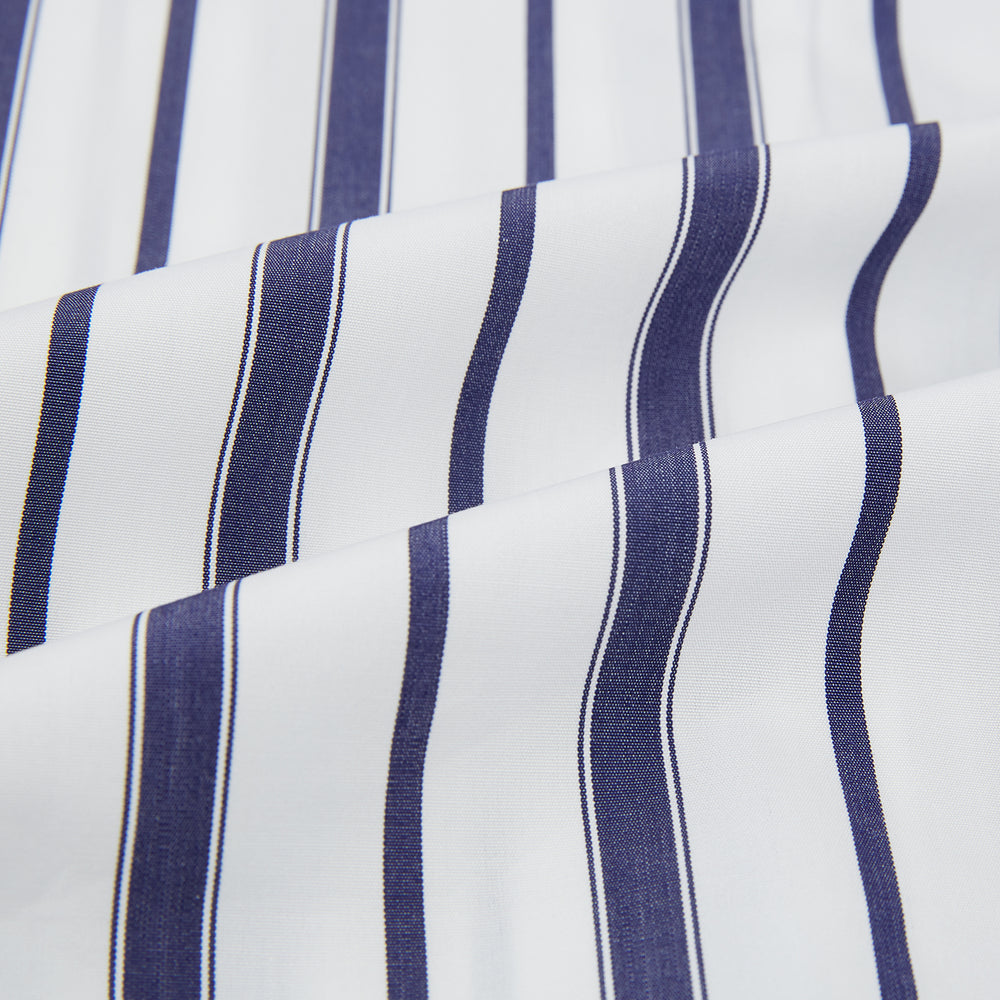 The Turnbull & Asser Navy Double Stripe Quarzo Nightshirt, a knee-length Italian cotton nightshirt with navy and white vertical stripes, collar, chest pocket, and button-down front, is displayed flat on a white background.