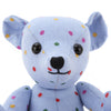 View 2 of product The Turnbuline Cotton Spot Teddy Bear by Turnbull & Asser is a blue gingham bear with colorful polka dots, black button eyes, a black nose, and a white leg label, shown sitting upright in profile facing left.