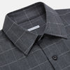 View 2 of product The Turnbull & Asser Charcoal Melange Check Hampstead overshirt, a long-sleeve button-up with a collar and two zippered side pockets, is laid flat on a light gray background.