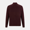 View 3 of product The Turnbull & Asser Burgundy Merino High Neck Zipped Cardigan features long sleeves, a zip-up front, and ribbed collar, cuffs, and hem, crafted from soft merino knitwear and shown on a white background.