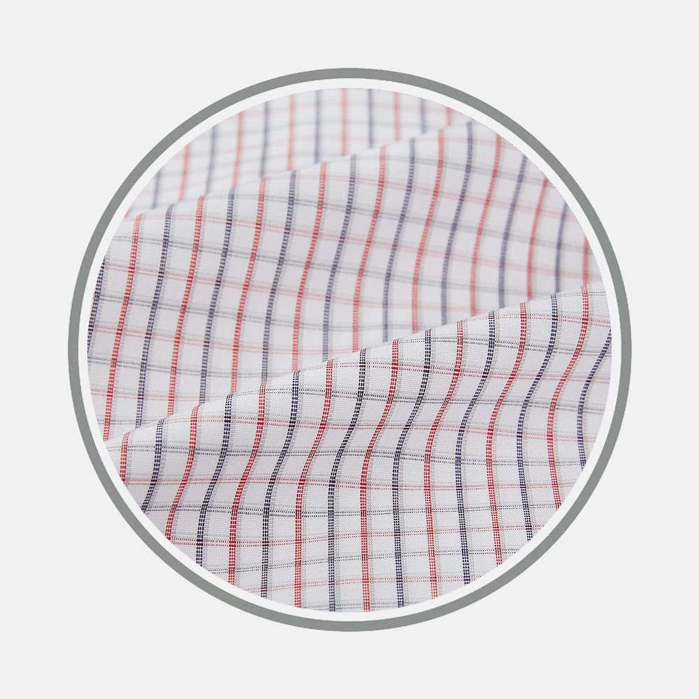 Close-up of Turnbull & Asser's Red And Blue Micro Tattersall Fabric, showing a white base with fine red and blue grid lines, displayed inside a circular frame on a plain background.