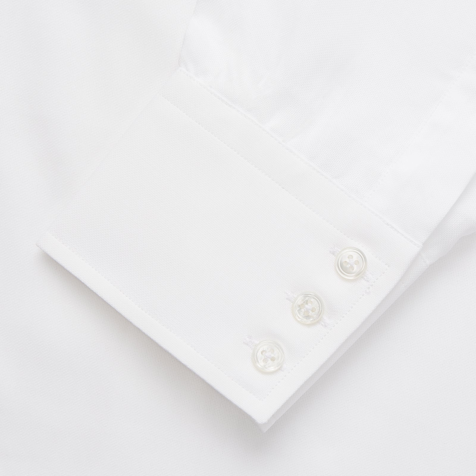 View 3 of product The Turnbull & Asser White Cotton Voile Regular Fit Mayfair Shirt features long sleeves, a pointed collar, button-down front, and buttoned cuffs, displayed flat against a plain white background.
