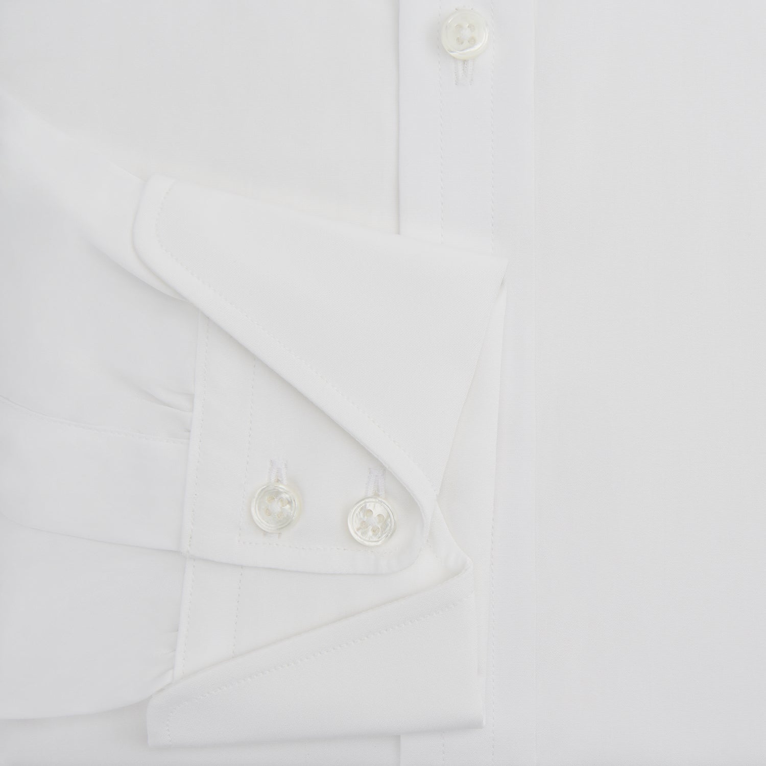 View 4 of product The Turnbull & Asser White Poplin Shirt With Regent Collar and 2-Button Cocktail Cuffs, featuring long sleeves, is buttoned up and laid flat on a white background.