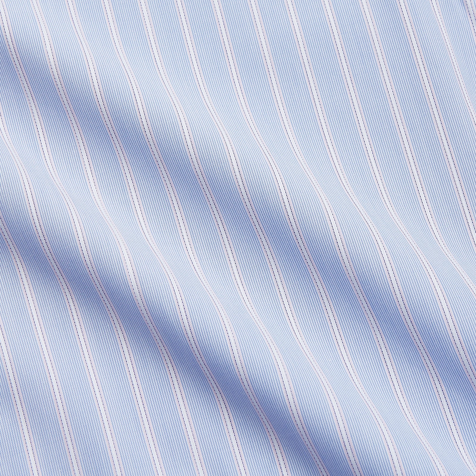 View 4 of product The Turnbull & Asser Blue Multi Stripe Cotton Regular Fit Whitby Shirt features white vertical stripes, long sleeves, button-down front, pointed collar, and buttoned cuffs, shown laid flat on a white background.
