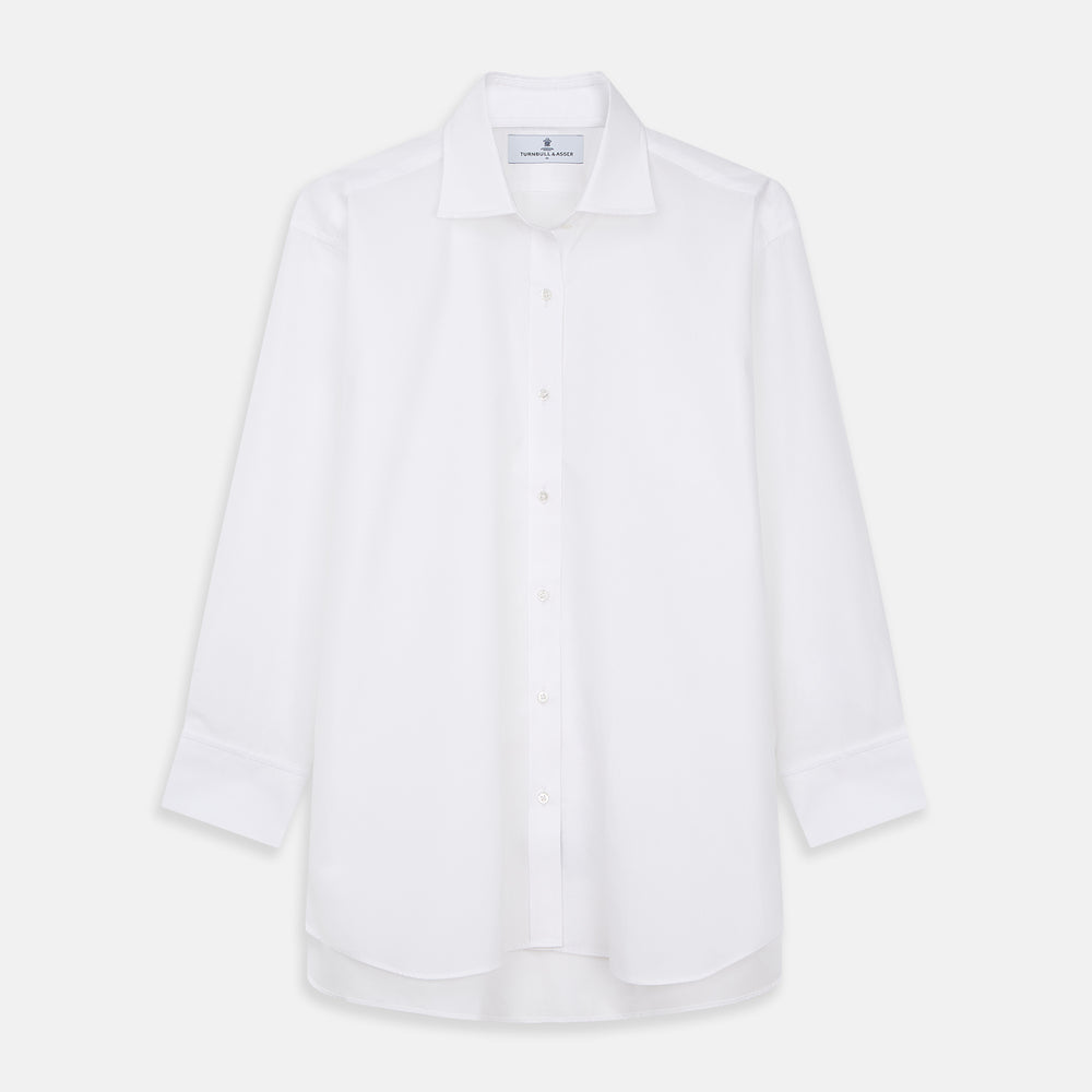 A woman with straight brown hair pulled back wears the Turnbull & Asser White Cotton Marlene Shirt, featuring classic menswear details, paired with high-waisted cream trousers against a neutral background.