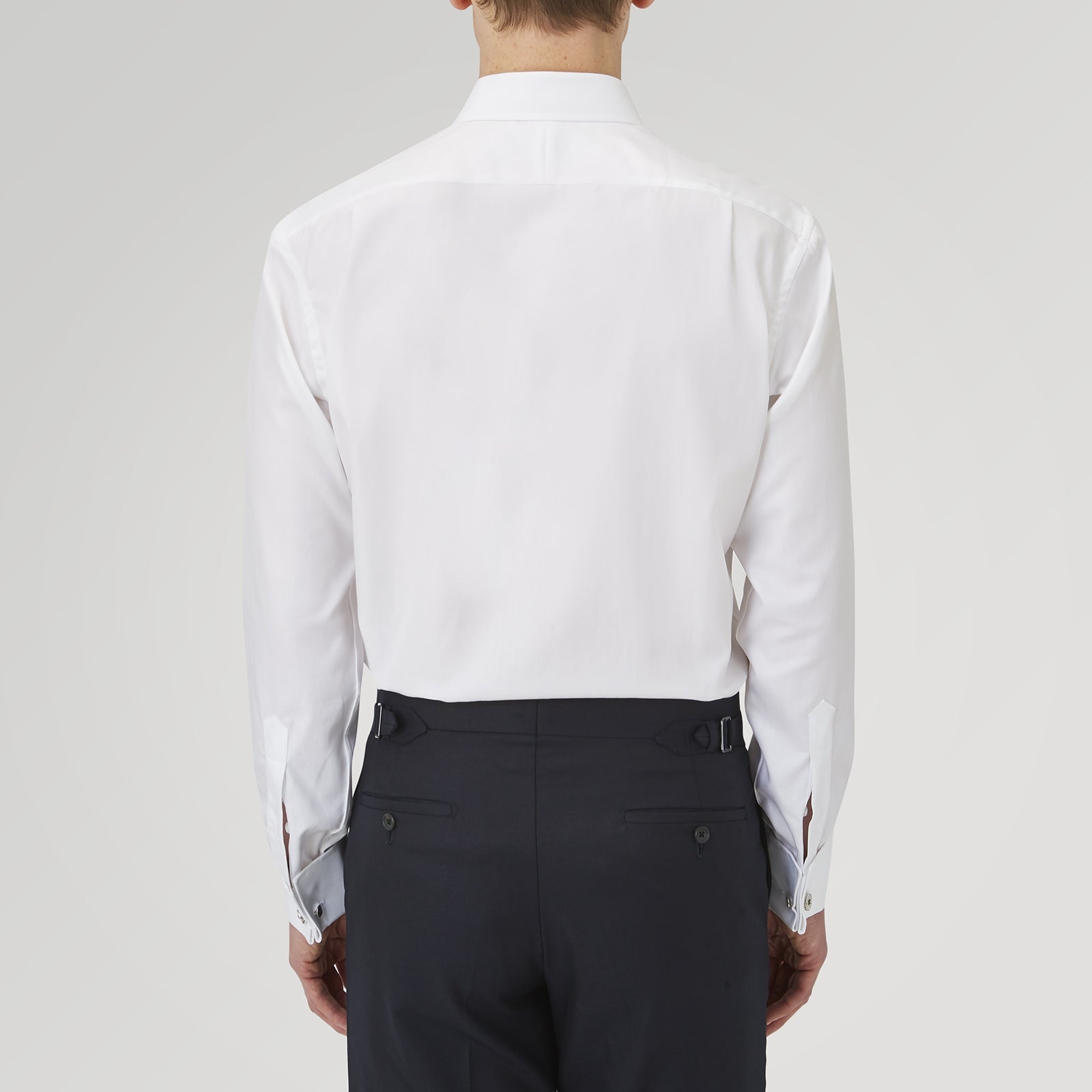 View 3 of product The Turnbull & Asser White Herringbone Sea Island Quality Cotton Shirt features a T&A collar, double cuffs, and chest pocket. Crafted for luxury with a classic design, it’s shown neatly folded against a light grey background—ideal for evening wear.