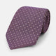 The Turnbull & Asser Lilac and Purple Micro Dot Silk Tie, featuring small white dots, is a stylish accessory for smart attire. Displayed rolled-up on a light background.