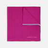 View 1 of product The Fuchsia and White Piped Silk Pocket Square by Turnbull & Asser features white edges and the brand’s name printed in white in the bottom right corner—a timeless men’s accessory.
