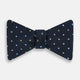 The Turnbull & Asser Lime Green and Sky Blue Spot Silk Bow Tie features a textured navy background with light blue and lime green polka dots, shown on a white background—a timeless men's accessory.
