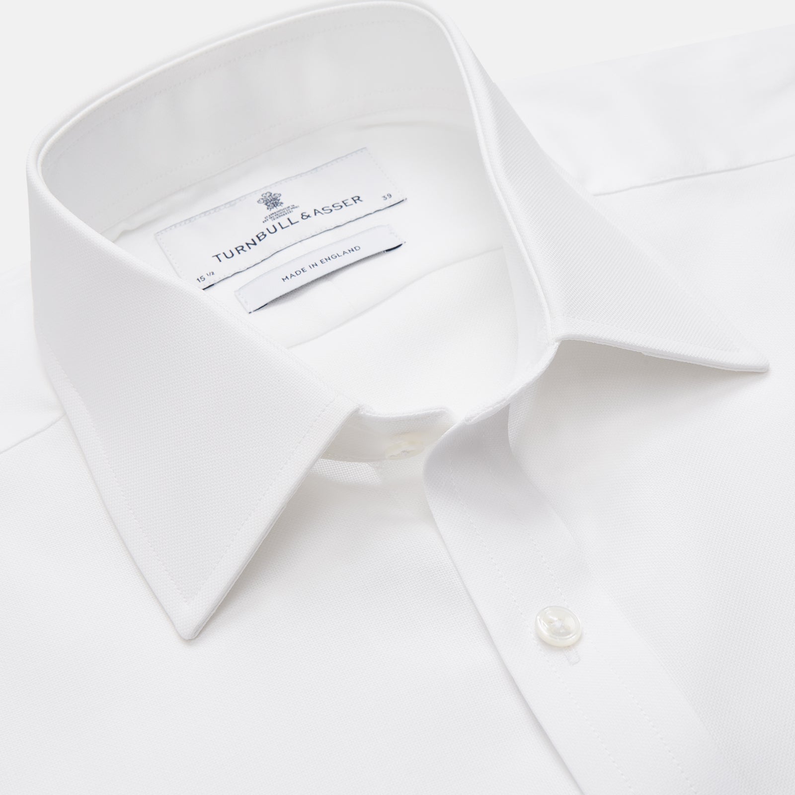 View 4 of product The Turnbull & Asser White Cotton Voile Regular Fit Mayfair Shirt features long sleeves, a pointed collar, button-down front, and buttoned cuffs, displayed flat against a plain white background.