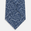 View 3 of product The Turnbull & Asser Pale Blue Paisley Silk Tie, featuring a blue paisley pattern on a pale blue background, is shown rolled up on a plain white surface.