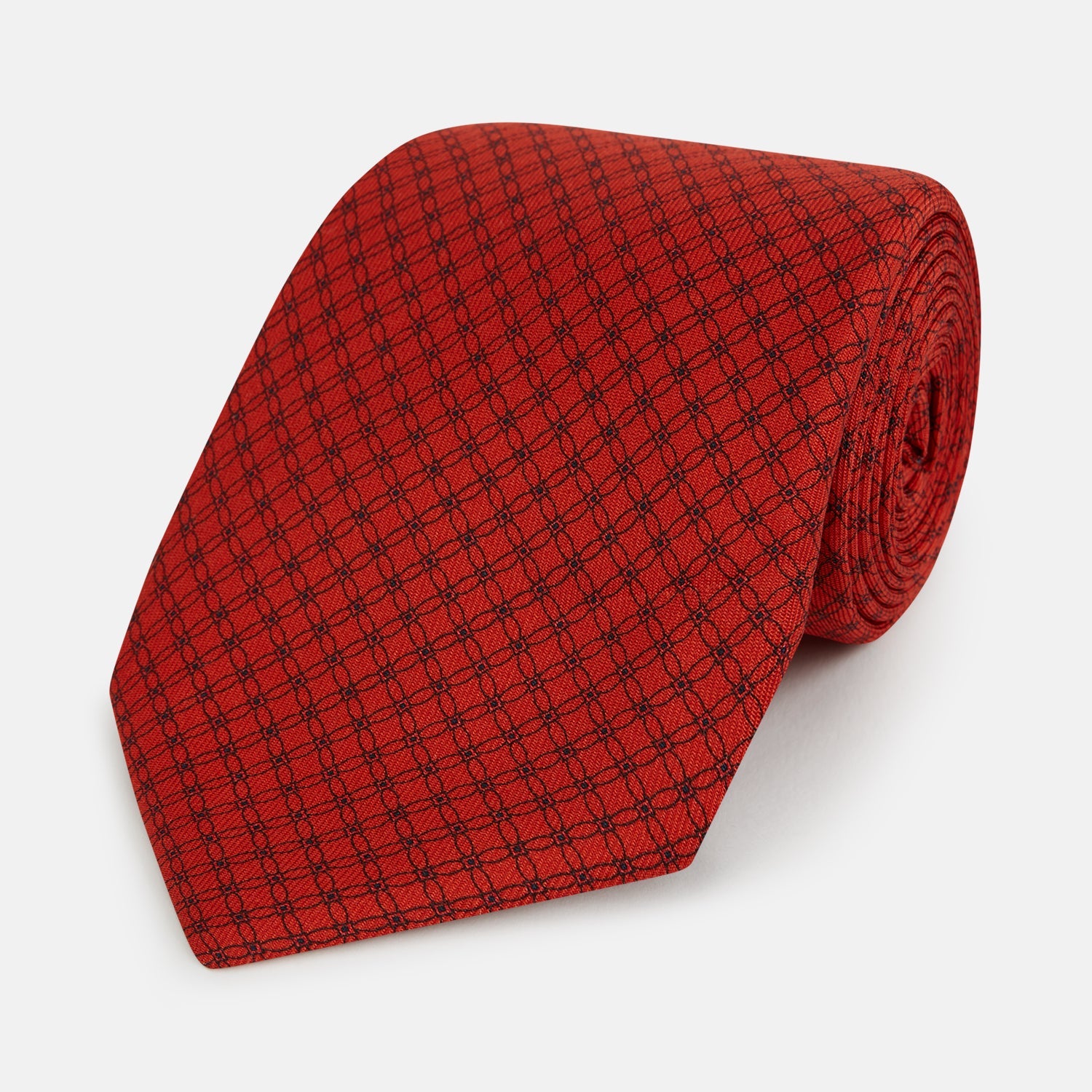View 1 of product The Turnbull & Asser Red Lattice-Patterned Silk Tie features a subtle black lattice design with small circular motifs, shown rolled up on a plain white background.