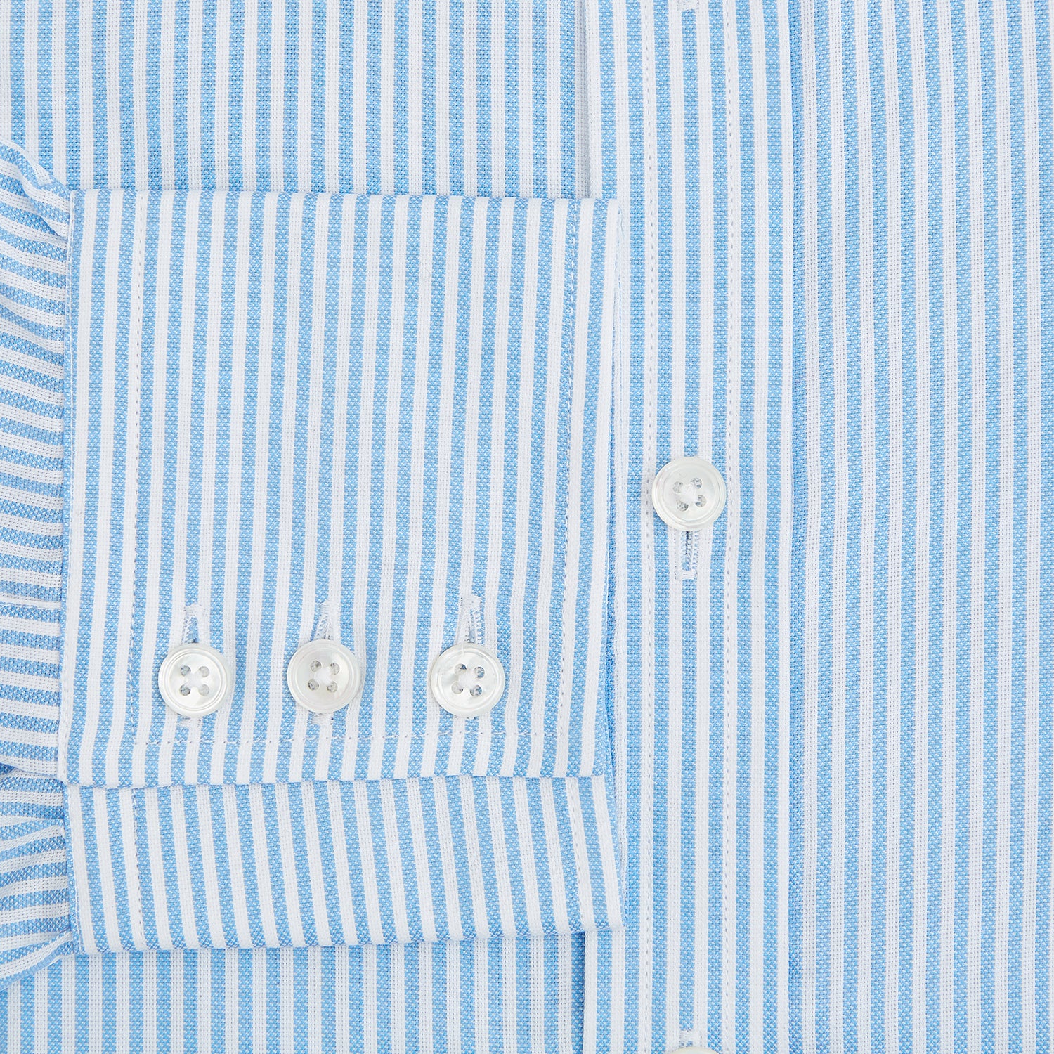 View 4 of product The Turnbull & Asser Blue Bengal Stripe Mayfair Shirt features light blue and white vertical stripes, a classic T&A collar, white buttons, and buttoned cuffs. Laid flat on a white background.