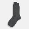 View 2 of product The image shows a single Turnbull & Asser Dark Steel/Navy Polka Dot Mid-Length Sock standing upright on a plain white background, featuring a ribbed cuff and a smooth, seamless finish.