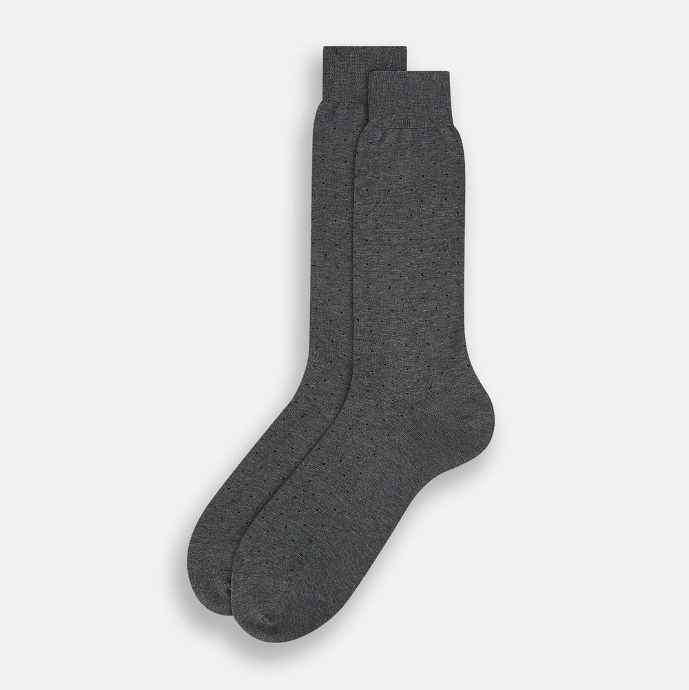 The image shows a single Turnbull & Asser Dark Steel/Navy Polka Dot Mid-Length Sock standing upright on a plain white background, featuring a ribbed cuff and a smooth, seamless finish.