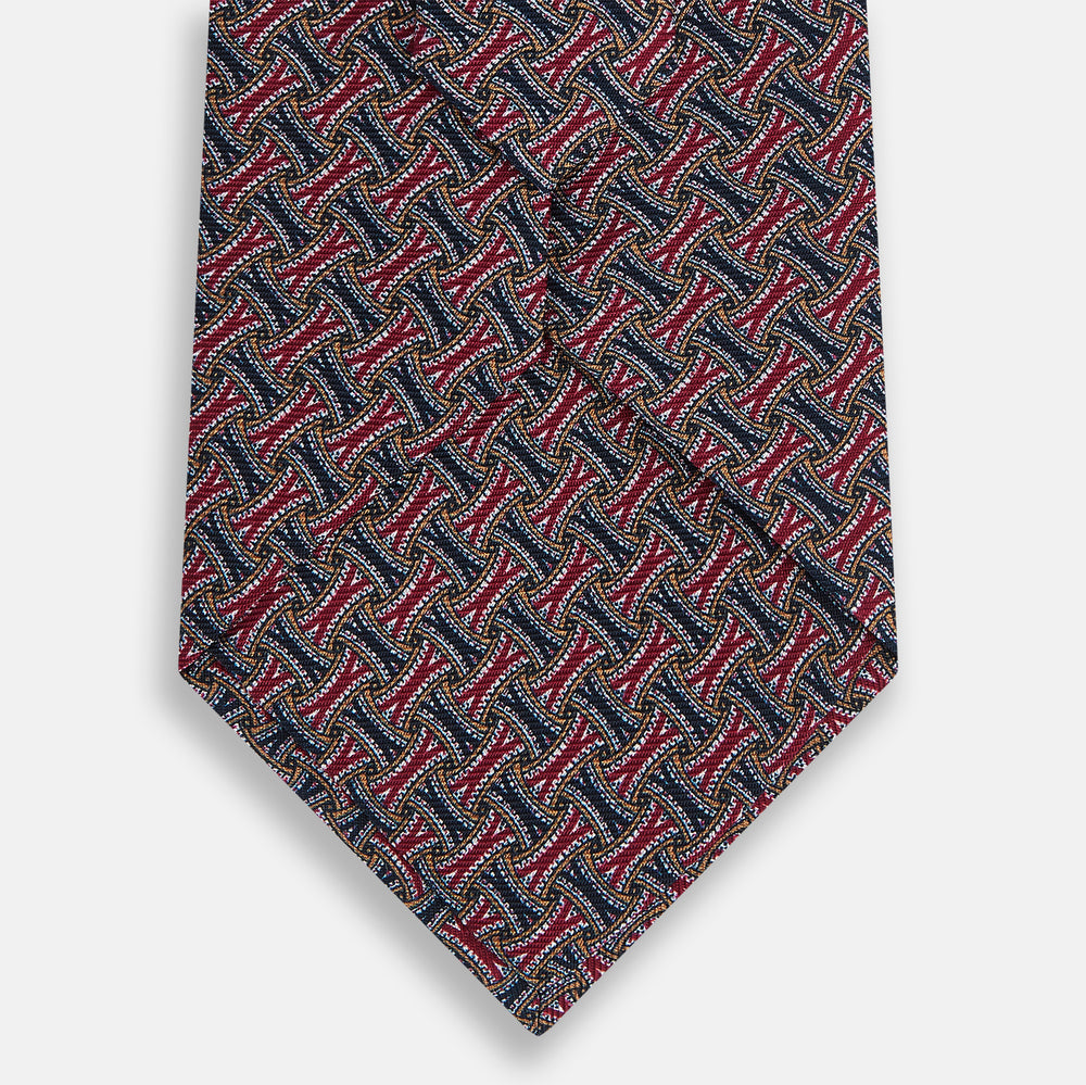 The Turnbull & Asser Burgundy and Navy Weave Patterned Silk Tie features a geometric design in rich tones on silk fabric.