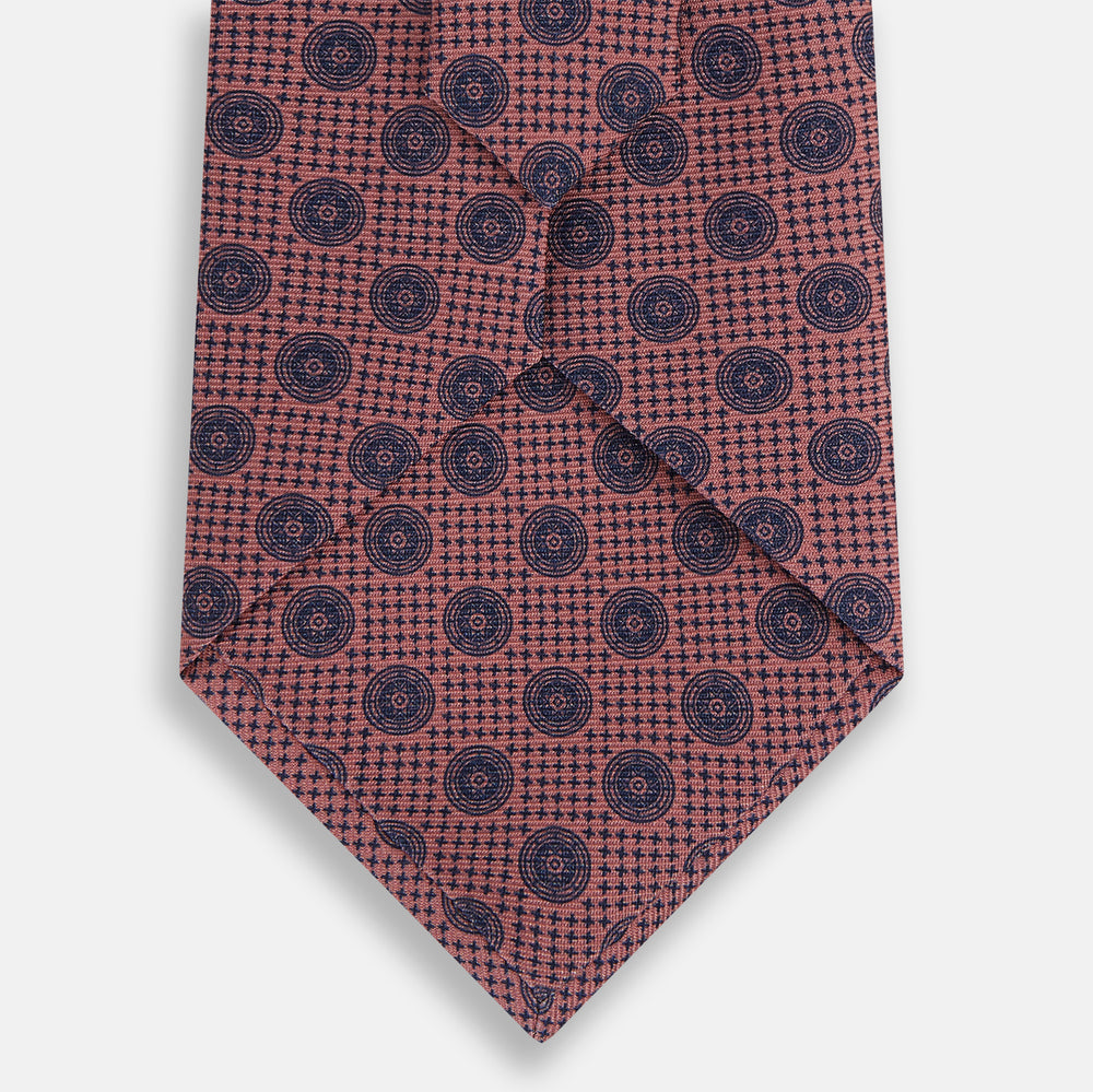 The Antique Pink Medallion Silk Tie by Turnbull & Asser is a men's luxury accessory, crafted from English silk in antique pink and detailed with small navy blue medallion motifs.