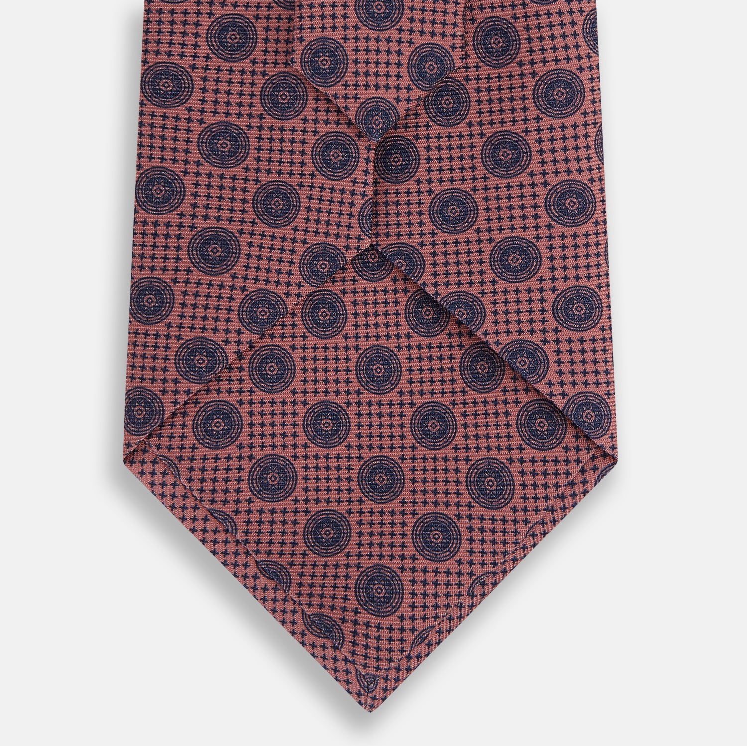 View 3 of product The Antique Pink Medallion Silk Tie by Turnbull & Asser is a men's luxury accessory, crafted from English silk in antique pink and detailed with small navy blue medallion motifs.