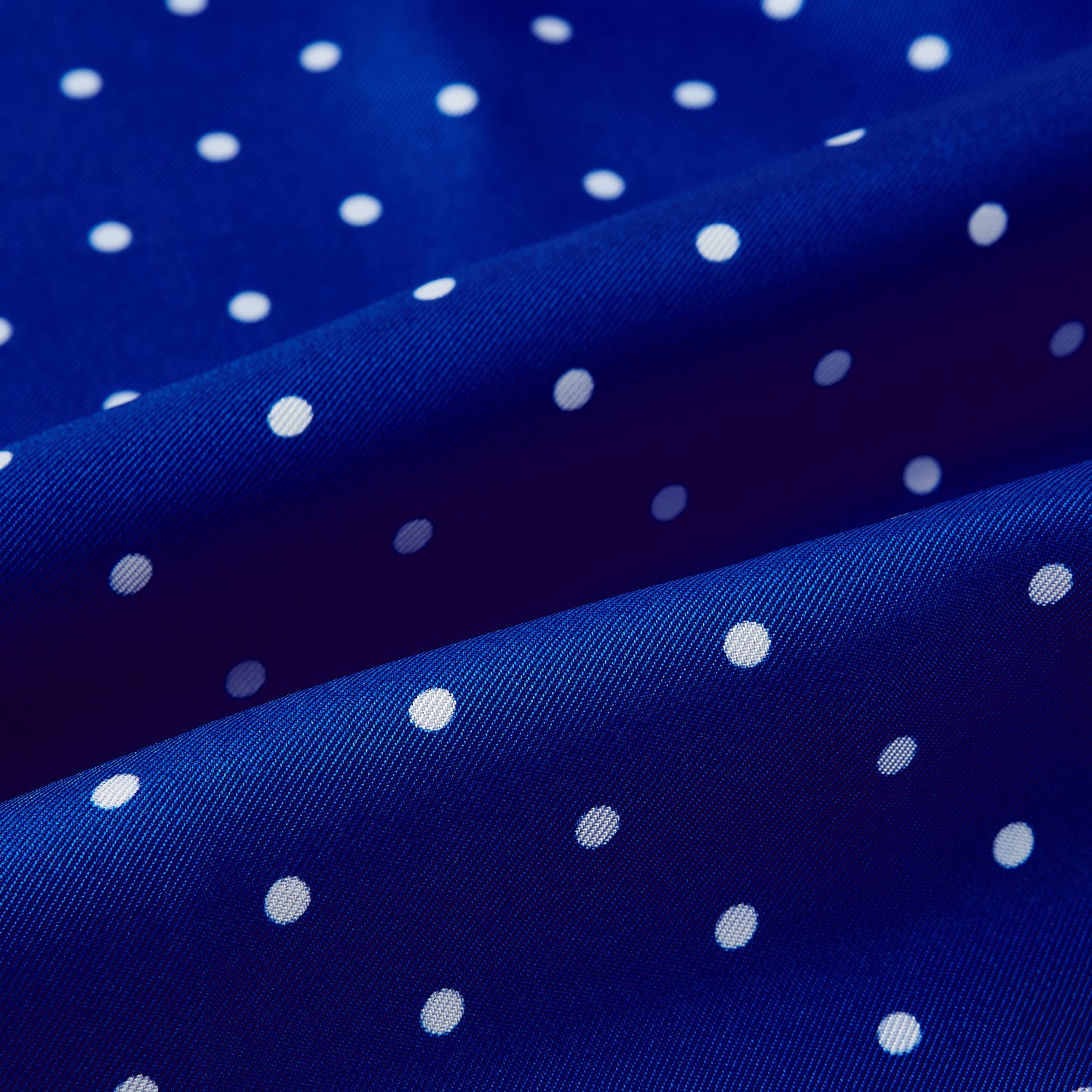 View 3 of product The Turnbull & Asser Royal Blue and White Spotted Silk Scarf features evenly spaced small white dots, fringed edges, and the brand’s name printed near the ends.