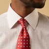 View 4 of product A man stands against a beige background, facing forward with a neutral expression and arms relaxed, wearing the Turnbull & Asser Red Multi Check Regular Fit Mayfair Shirt.