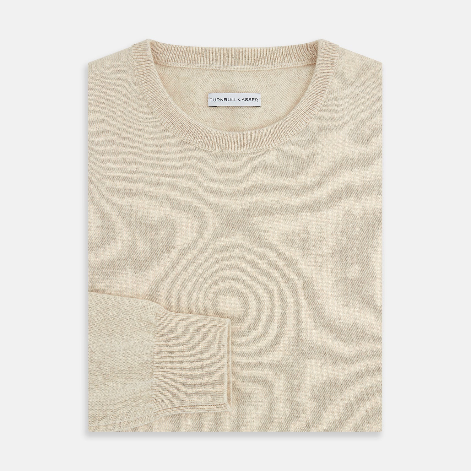 View 4 of product The Turnbull & Asser Cream Cashmere Round Neck Jumper features long sleeves, ribbed cuffs, and a ribbed hem—a versatile men’s knitwear staple, shown against a white background.