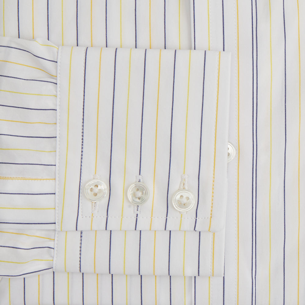 The Turnbull & Asser Yellow Double Pinstripe Mayfair Shirt, a long-sleeved, button-up with thin blue and yellow stripes on white, classic T&A collar, and buttoned cuffs, is laid flat on a white surface.
