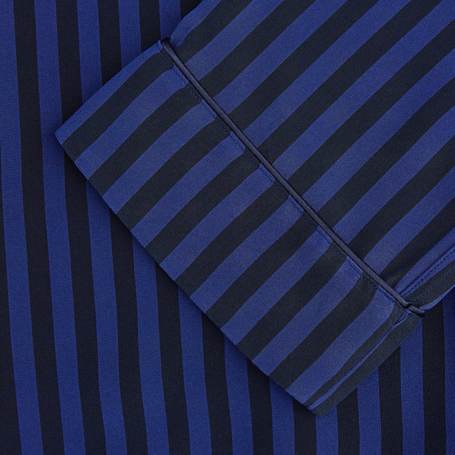 View 3 of product The Turnbull & Asser Blue and Navy Candy Stripe Silk Hyde Pyjamas Set features a long-sleeve button-up top with a chest pocket and elastic-waist pants, shown on a plain white background.