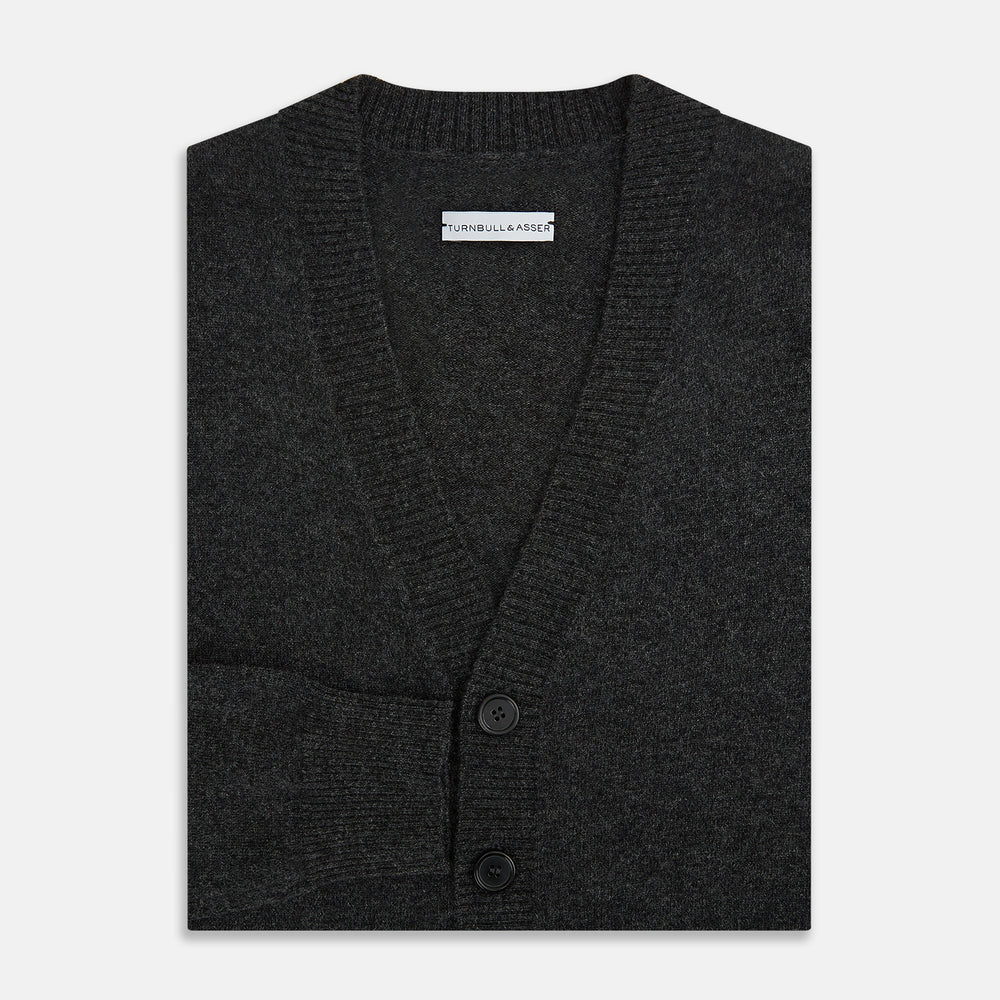 The Turnbull & Asser Dark Grey Melange Cashmere Cardigan features long sleeves, ribbed cuffs and hem, and two front pockets, shown on a plain white background.
